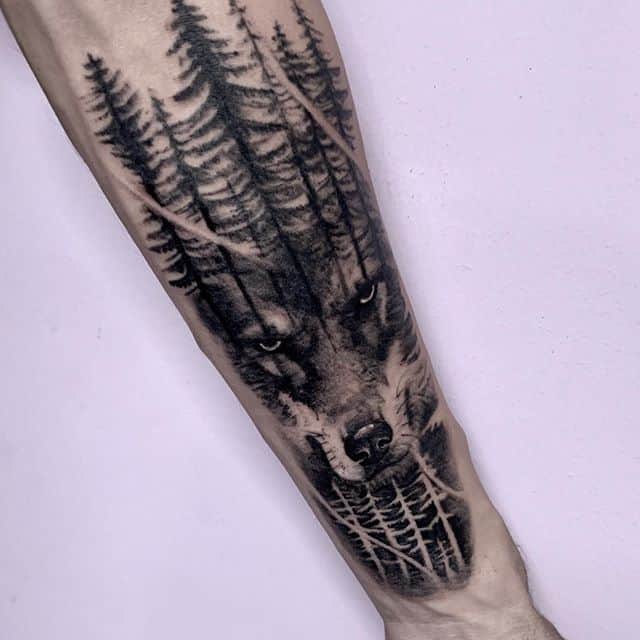 Тату волк в лесу в реалистичном стиле