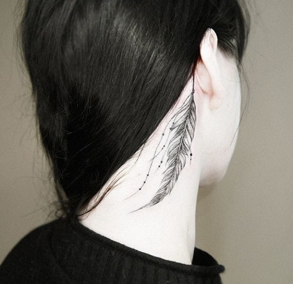 тату перо за ухом