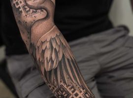 Яскравий тату-арт птахи на руці з геометричними елементами. чапля і вишиванка тату