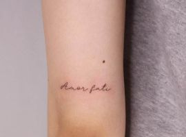 Мінімалістичне татуювання "Amor fati" на руці, символ прийняття долі та життєвого шляху. Татуювання "Amor fati" на руці, мінімалістичний стиль.
