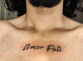 Підпис до зображення: Чоловік з татуюванням "Amor Fati" на грудях у тату-салоні Альянс, символ прийняття долі. Тату "Amor Fati" на грудях у чоловіка, тату-салон Альянс.