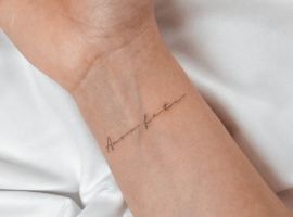Мінімалістичне тату "Amor Fati" на зап'ясті, що символізує прийняття долі та життєвий філософський підхід. Тату "Amor Fati" на зап'ясті, символ прийняття долі та життєвого шляху.
