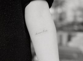Естетичне тату "Amor Fati" на руці, що символізує прийняття долі та життєвого шляху. Тату "Amor Fati" на руці, символ прийняття долі та життєвого шляху.