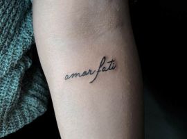 Мінімалістичне тату "Amor Fati" на руці, символ прийняття долі та філософії життя. Тату "Amor Fati" на руці, стильне і мінімалістичне.