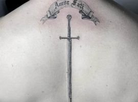 Татуювання меча з латинським написом "Amor Fati" на спині, символізує прийняття долі та життєвий філософський підхід. тату amor fati