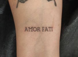 Тату "Amor Fati" с бабочкой, символ принятия судьбы и любви к жизни, выполнено в стиле реализм. Тату "Amor Fati" на руке с бабочкой, символ принятия судьбы.