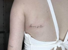 Модель з татуюванням "Amor Fati" на спині, що символізує прийняття долі та життєвий шлях. Тату "Amor Fati" на плечі, символ прийняття долі та життєвого шляху.