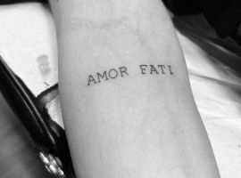 Малюнок "Amor Fati" на руці, тату в стилі мінімалізм, створене в Тату Салон Альянс. Татуювання "Amor Fati" на передпліччі, чорний шрифт.