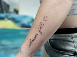 Маленьке тату Love Fati з сердечком на руці, символ прийняття життєвого шляху та філософії amor fati. Тату Love Fati з сердечком на руці, символ прийняття долі.