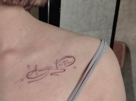 Тату "Amor Fati" на плечі, створене в салоні Альянс, символізує прийняття долі та життєвий філософський підхід. Тату "Amor Fati" на плечі, стильне та мінімалістичне, в салоні Альянс.