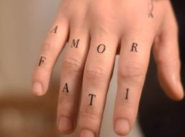 Малюнок "Amor Fati" на пальцях руки, символ філософії прийняття життєвих обставин. Татуювання "Amor Fati" на пальцях руки, символ прийняття долі.
