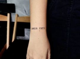 Малюнок татуювання "Amor Fati" на руці, символ прийняття долі та філософії життя. Татуювання "Amor Fati" на зап'ясті, стильний дизайн.