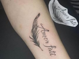 Підпис до зображення: Тату "Amor Fati" з пером, символ прийняття долі та філософії життя, зроблене у тату салоні Альянс. Тату "Amor Fati" з пером на передпліччі, символ прийняття долі.