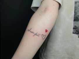 Малюнок тату "Amor Fati" з маленьким серцем на руці, символ прийняття долі та життєвого шляху. Тату "Amor Fati" з серцем на руці, стильне та значуще.