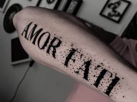 Татуювання "Amor Fati" на руці, символ прийняття долі та життєвого шляху, створене майстрами Тату Cалон Альянс. amor fati татуювання