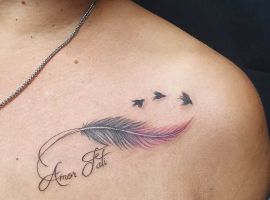 Тату "Amor Fati" з пір'ям і птахами на плечі, символ прийняття долі та життєвого шляху. Тату "Amor Fati" з пір'ям і птахами на плечі, символ прийняття долі.