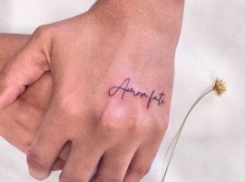 Мінімалістичне тату "Amor fati" на руці, що символізує прийняття життєвих випробувань та філософію. Тату "Amor fati" на руці, символ прийняття долі та життєвого шляху.