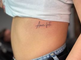 Мінімалістичне тату "Amor Fati" на боці, символ прийняття долі та життєвого шляху. Тату "Amor Fati" на боці, стильне і мінімалістичне.