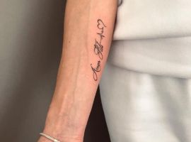 Модель з татуюванням "Amor Fati" на руці, що символізує прийняття життєвого шляху та філософію. Татуювання "Amor Fati" на руці, стильний дизайн, символ прийняття долі.