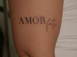 Мінімалістичне тату "Amor Fati" на руці, символ прийняття долі та любові до життя, створене в тату-салоні Альянс. Стильне тату "Amor Fati" на руці, чорний шрифт, мінімалістичний дизайн.