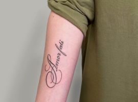 Тату "Amor Fati" на руці, символ прийняття долі та життєвого шляху, виконане у витонченому стилі. Тату "Amor Fati" на руці, символ прийняття судьби та життєвого шляху.