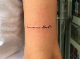 Малюнок татуювання "amorfati" у стилі рукопису на руці, створений у тату салоні Альянс, символізує прийняття долі та життєвий шлях. Татуювання "amorfati" на руці, стиль рукопису, тату салон Альянс.