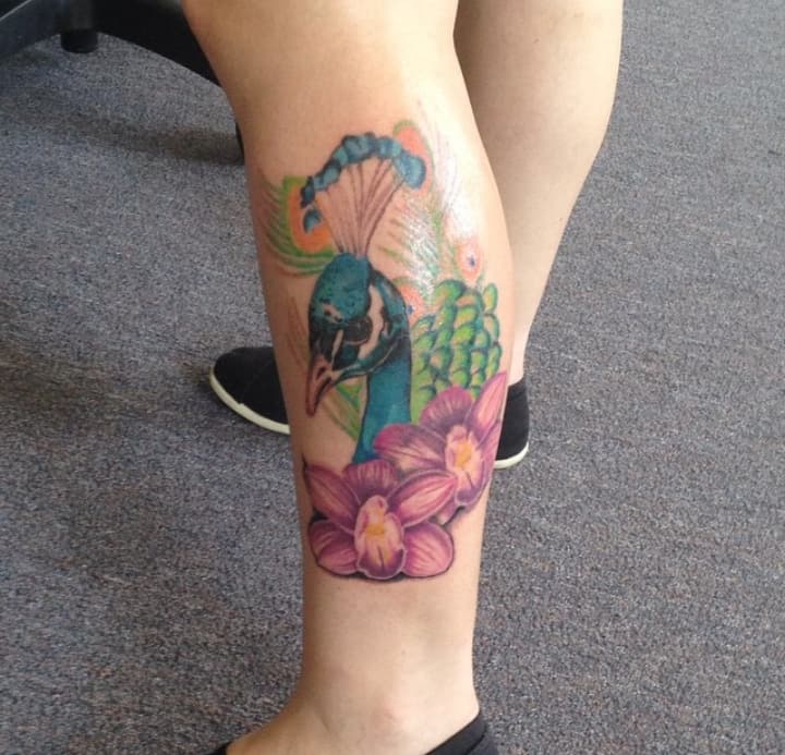 Тату павлин на икре